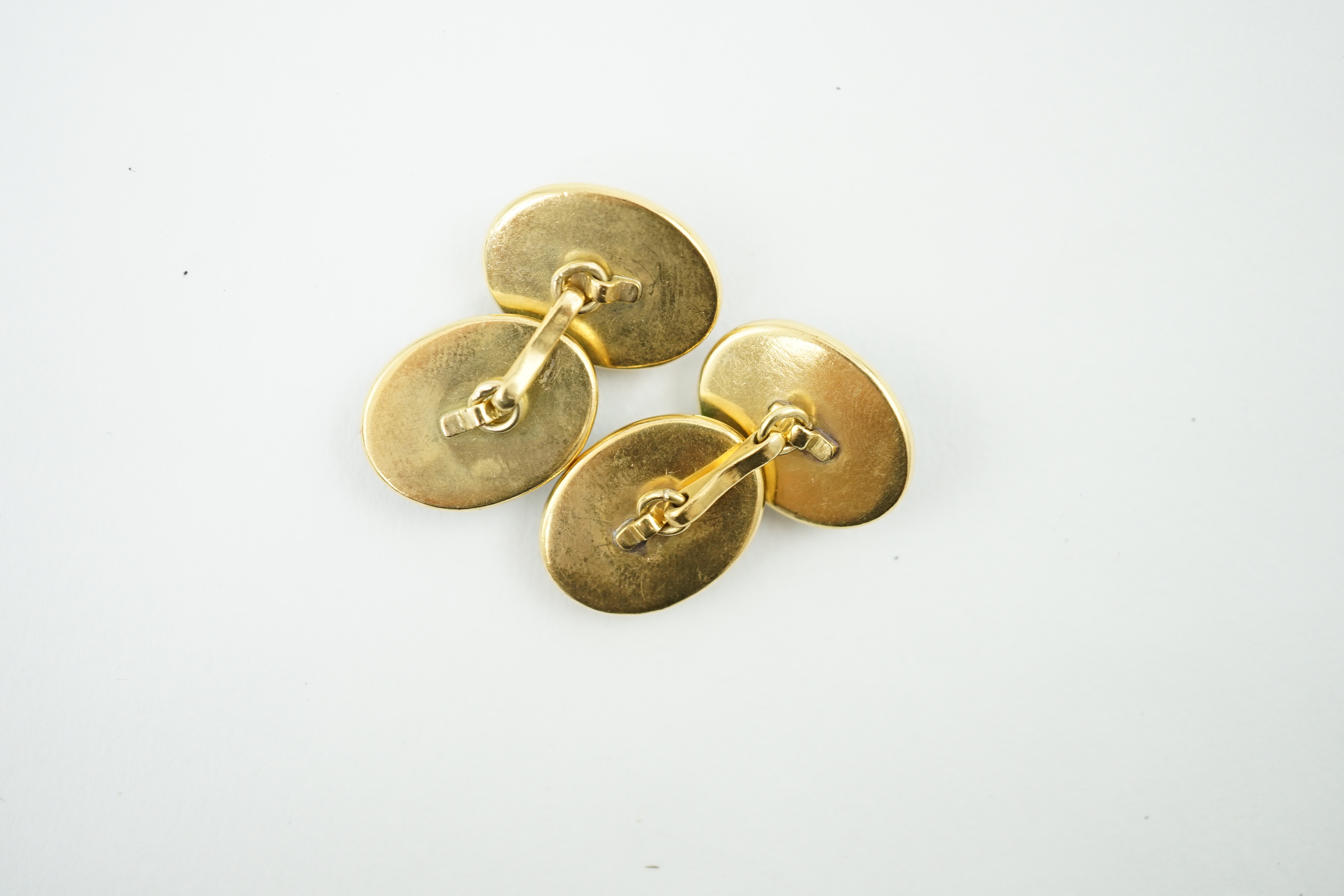 A pair of early to mid 20th century gold and Essex crystal set oval cufflinks, each decorated with a Scottie dog, 20mm, gross weight 23.4 grams. Condition - fair